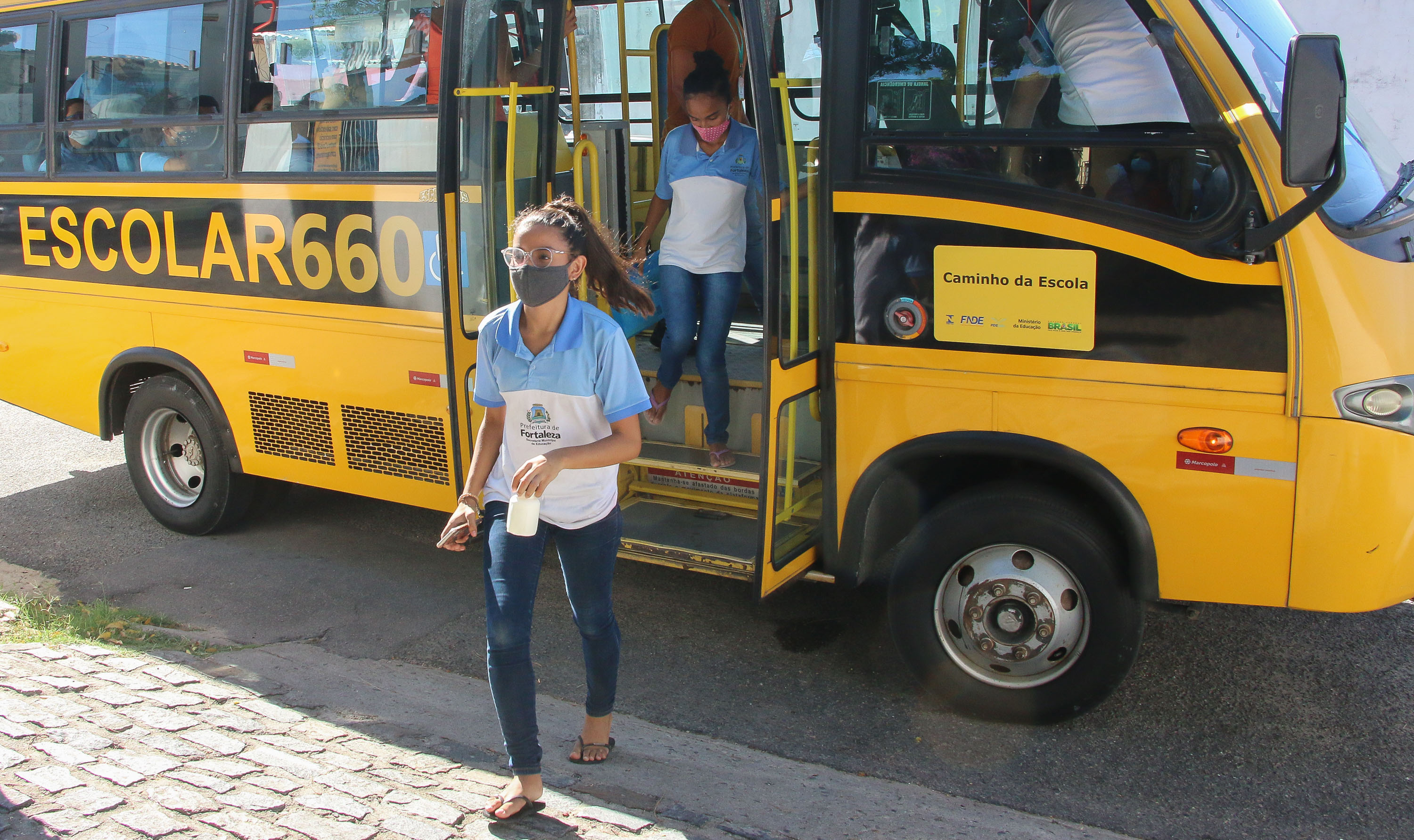 alunos descendo do ônibus escolar